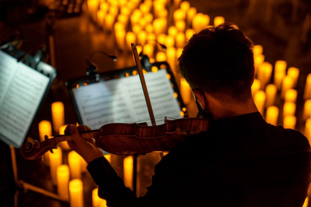 a violinist performing at a candlelight concert