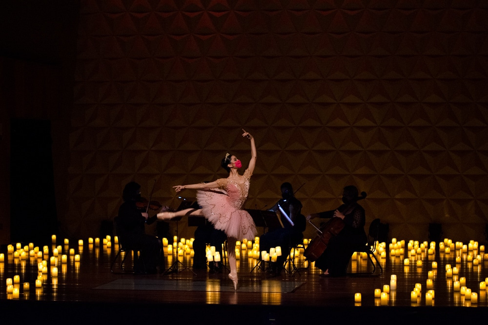 ballerina in pink tutu dances among candlelight