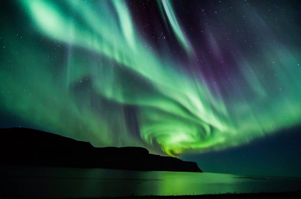 northern-lights-green-blue-shades-across-water
