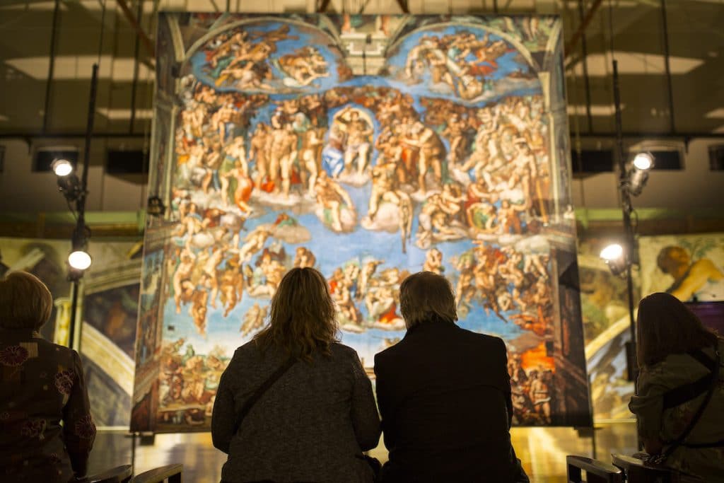 visitors admiring the Sistine Chapel exhibition