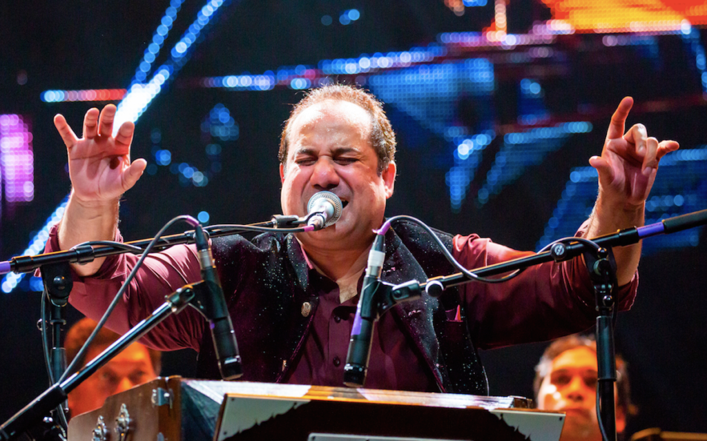 pakistani singer Rahat Fateh Ali Khan with arms raised singing into a microphone